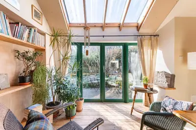 a conservatory with a glass door and plants at B&B on Beautiful Organic Homestead, Edinburgh in Loanhead