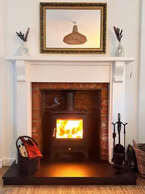 a fireplace with a fire in it in a living room at Drymen View in Drymen