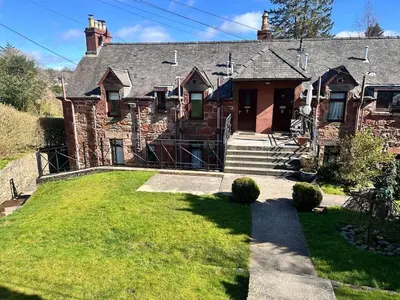 an old brick house with a grass yard at Drymen View in Drymen