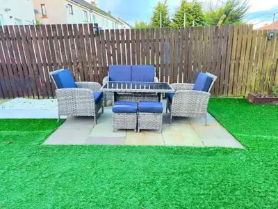 a patio with chairs and a table on green grass at Super luxury 2 bedroom, full house sleep 5 with garden & parking close to airport in Elderslie
