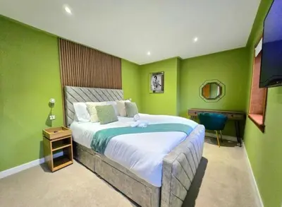 a bedroom with a large bed with green walls at Super luxury 2 bedroom, full house sleep 5 with garden & parking close to airport in Elderslie