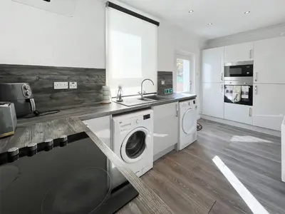 a kitchen with a washing machine and a sink at Cambusmoon Apartment in Gartocharn