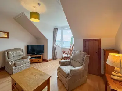 a living room with two chairs and a tv at Glengilp Apartment - Uk49317 in Ardrishaig