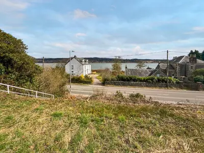 a view of a street with a house and a lake at Glengilp Apartment - Uk49317 in Ardrishaig