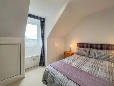 a bedroom with a large bed and a window at Glengilp Apartment - Uk49317 in Ardrishaig
