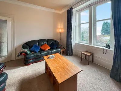 a living room with a leather couch and a table at Glenfyne Apartment - Uk49318 in Ardrishaig