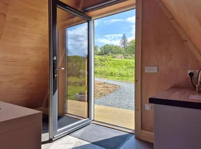 a kitchen with a sliding glass door in a house at The Hideouts at Port nan Gael Campsite in Pennyghael