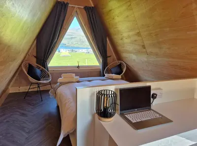 a laptop on a desk in a tiny house at The Hideouts at Port nan Gael Campsite in Pennyghael