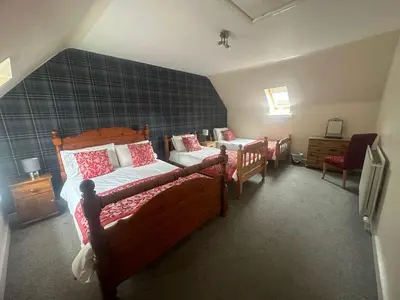 a bedroom with two beds and a couch in it at Belton House Guest Rooms in Wanlockhead