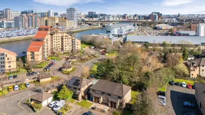 an aerial view of a city with a river and buildings at Cairn BNB Introduces Mavisbank Gardens - where homely charm meets modern living in Glasgow