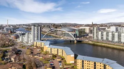 a city with a bridge over a river and buildings at Cairn BNB Introduces Mavisbank Gardens - where homely charm meets modern living in Glasgow