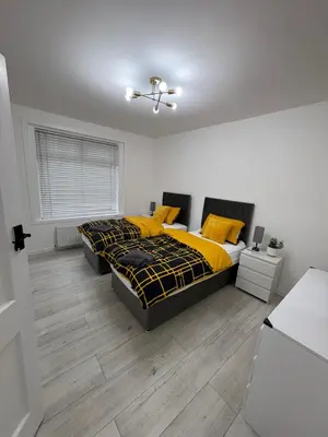 a bedroom with a bed with yellow pillows at Cozy 3 Bed Home, Free Parking 8 min to City Centre in Cowlairs