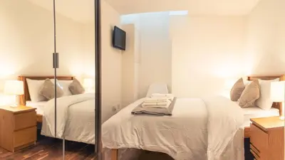 a bedroom with two beds and a mirror at b&b in Edinburgh in Edinburgh