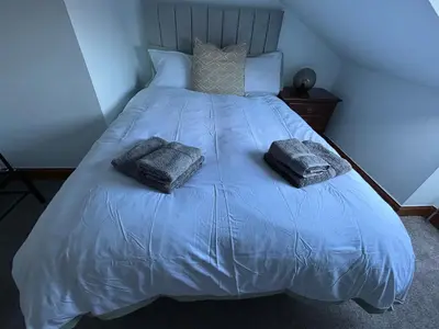 a blue bed with two pillows on top of it at Crescent Corner 44 Seamore Street 3 Bedroom in Largs