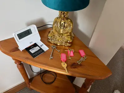 a table with a alarm clock and a clock and keys at Crescent Corner 44 Seamore Street 3 Bedroom in Largs