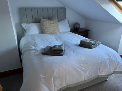 a bed with two towels and two pillows on it at Crescent Corner 44 Seamore Street 3 Bedroom in Largs