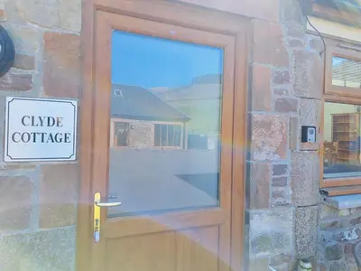 a wooden door with a sign that reads cubic concrete at Clyde Cottage in Lamington
