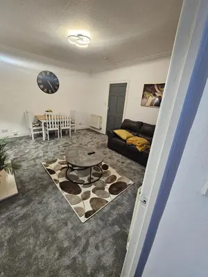 a living room with a couch and a table at Addex Apartment in Dunfermline
