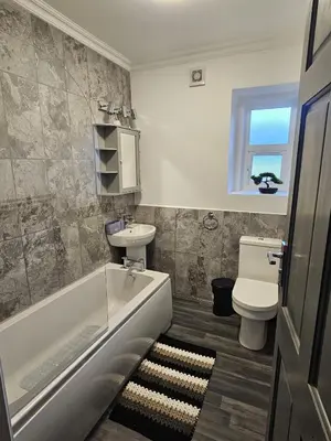 a bathroom with a tub and a sink and a toilet at Addex Apartment in Dunfermline