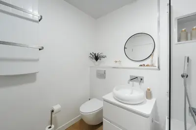 a white bathroom with a toilet and a sink at Central 1-bed flat - Walk to shops, pubs and station in Saltcoats