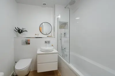 a white bathroom with a sink and a shower at Central 1-bed flat - Walk to shops, pubs and station in Saltcoats