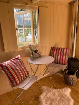 a room with a table and two chairs and a window at The Secret Shepherds Hut- Off Grid Retreat in New Galloway
