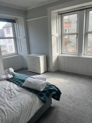 a white bedroom with a bed and two windows at Our Salad Days Lochgilphead in Lochgilphead