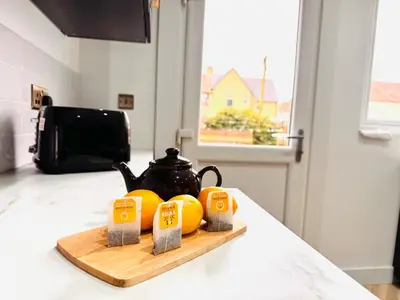 a cutting board with oranges and a tea kettle on a counter at Luxury Grangemouth accomodation with free parking in Falkirk