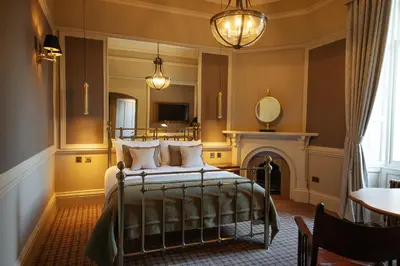 a bedroom with a bed and a fireplace at Cornhill Castle in Biggar