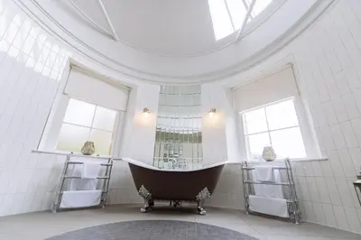 a bathroom with a large tub in a room with windows at Cornhill Castle in Biggar