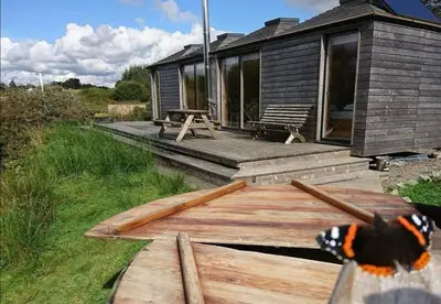 a wooden deck in front of a cabin at Red Kite Eco Bothy - with Hot Tub in Castle Douglas