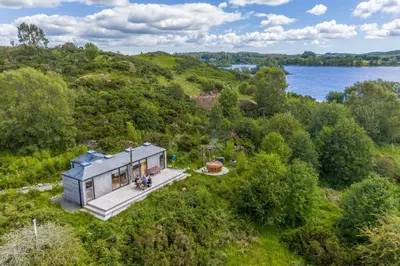 an overhead view of a tiny house on a hill next to a lake at Red Kite Eco Bothy - with Hot Tub in Castle Douglas