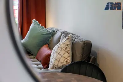 a reflection of a couch with pillows on it at 2 Bed Sleeps 4 in Dunfermline in Cairneyhill
