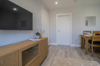 a living room with a large flat screen tv on a wall at Highfield Apartment- 2 Bed in Motherwell close to centre in Motherwell