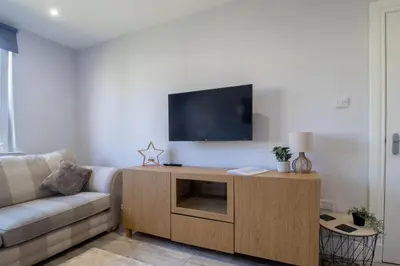 a living room with a couch and a flat screen tv at Highfield Apartment- 2 Bed in Motherwell close to centre in Motherwell