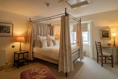 a bedroom with a canopy bed with a window at The Royal Hotel in Comrie