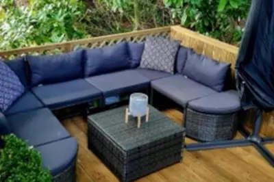 a blue couch sitting on top of a patio at Wildwood Cabin - Sleeps 6 Hot Tub & Parking in Beattock