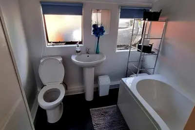 a bathroom with a toilet and a sink and a tub at Wildwood Cabin - Sleeps 6 Hot Tub & Parking in Beattock