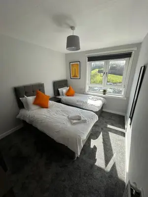 two beds in a room with a window at 3-Bed Apartment Central Greenock in Greenock