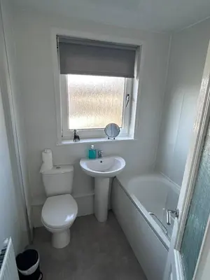 a bathroom with a toilet and a sink and a window at 3-Bed Apartment Central Greenock in Greenock