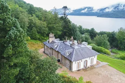 an aerial view of a house on a hill next to a lake at Sequoia House in Tarbet