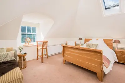 a bedroom with a bed and a desk and a window at Sequoia House in Tarbet