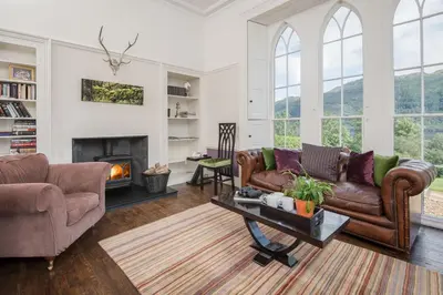 a living room with a couch and a fireplace at Sequoia House in Tarbet