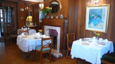 a dining room with two tables and a fireplace at Sandilands House in Edinburgh