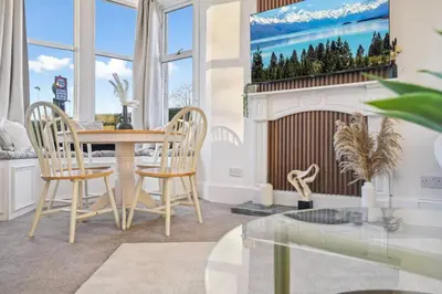 a dining room with a table and chairs and a fireplace at Large Terraced Home with Parking in Glasgow