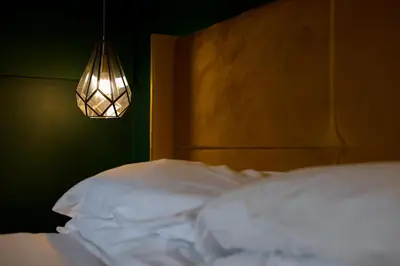 a bedroom with a bed with a headboard and a lamp at Netherbrae Apartment in Oban