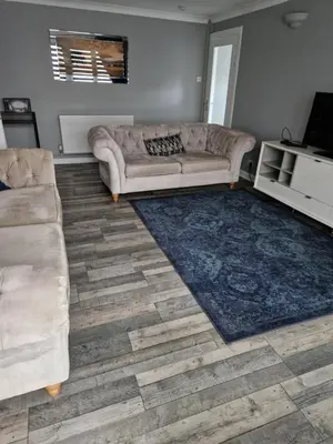 a living room with a couch and a rug at The Cottage in Kirk of Shotts