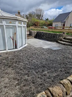 a backyard with a greenhouse and a patio at The Cottage in Kirk of Shotts