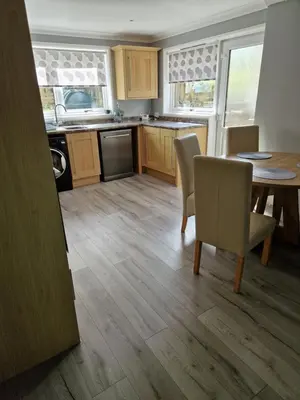 a kitchen with a table and chairs and a dining room at The Cottage in Kirk of Shotts