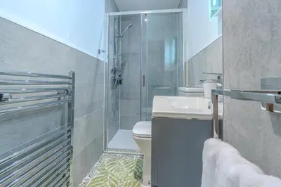 a bathroom with a shower and a toilet and a sink at Victorian Charm - Lush Garden, Shops and Parking in Edinburgh